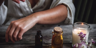 Huiles de soin, bougie et fleurs dans une ambiance chaleureuse
